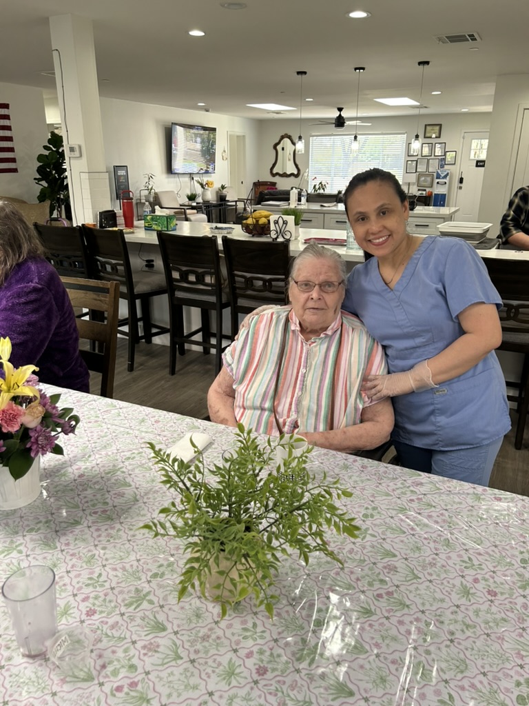 Caregiver with resident at Encompass Senior Living dining area