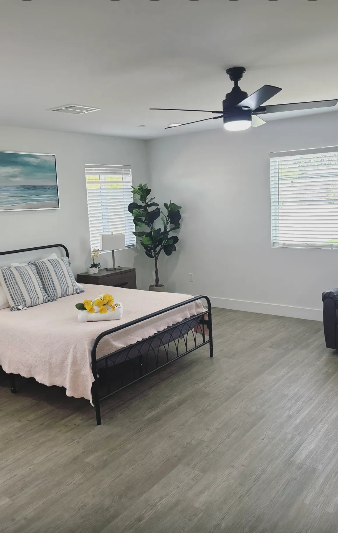 Bright resident room with adjustable bed, two nightstands, and comfortable recliner